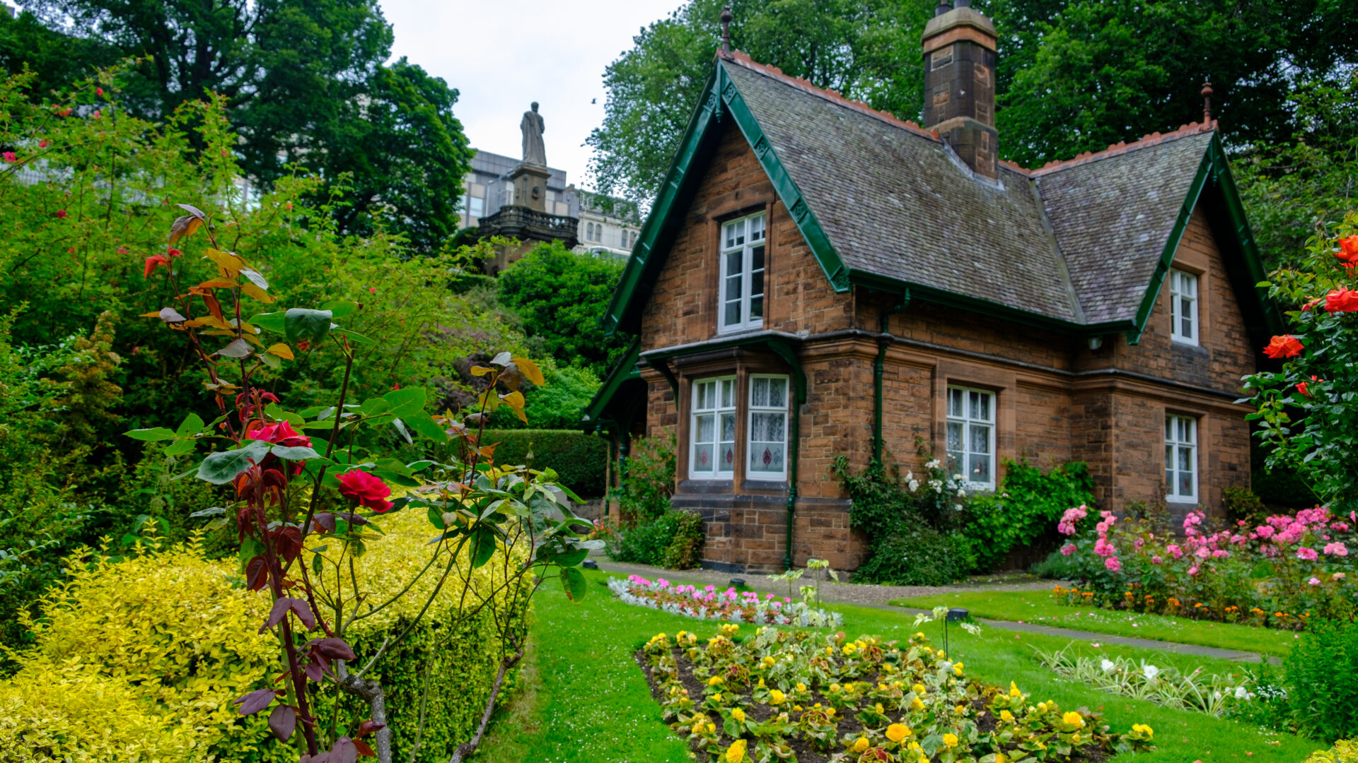 Historic stone cottage set within landscaped gardens, featuring period architectural details, mature planting and heritage property character.
